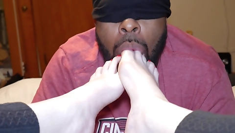 Amateur couple is playing with red painted toes on the bed